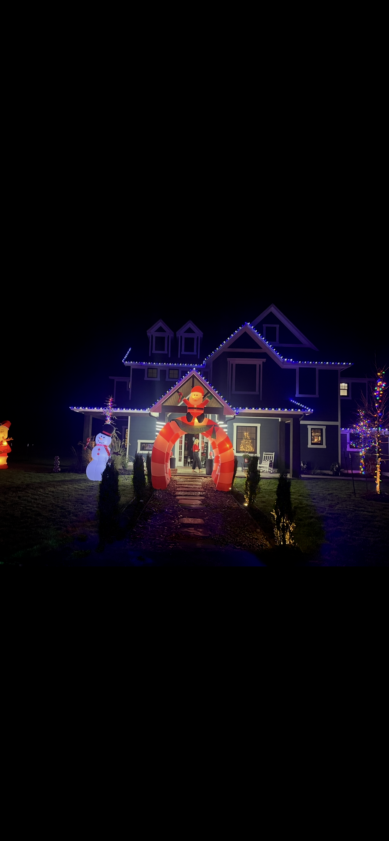 Holiday-lit home with a festive illuminated entry display